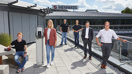 Sechs Personen stehen in Abstand zueinander auf der Dachterrasse. Im Hintergrund ist das MENNEKES Schild zu sehen.